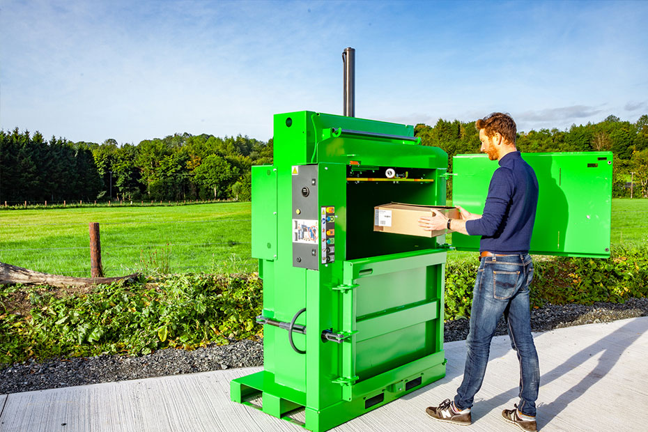 loading a cardboard box into a 100 baler